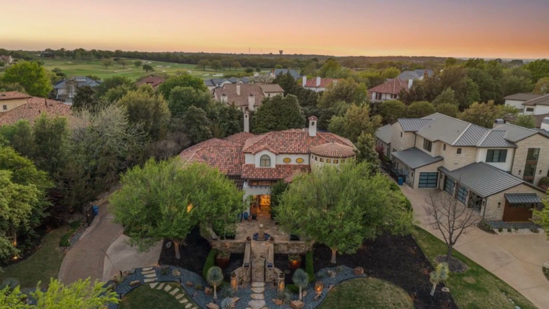 Aerial view of the estate at dusk inside the Vaquero Club, the tile roof at the center of the neighborhood
