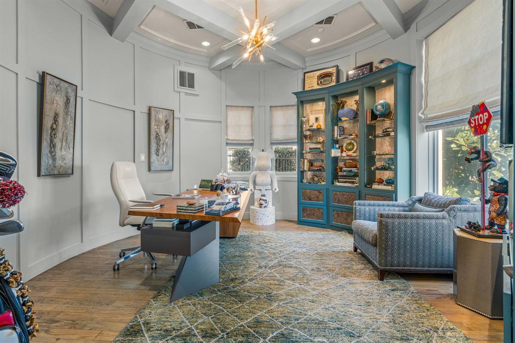 First-floor office with curved paneled walls, a walnut desk and teal glass display cabinets