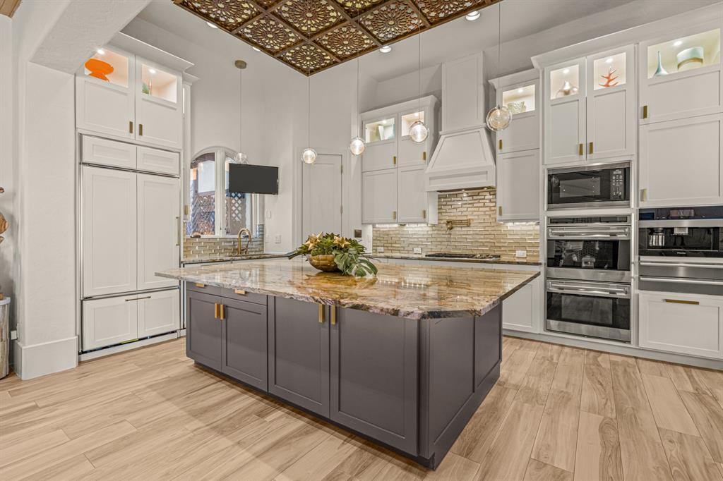 Kitchen appliance wall with a Sub-Zero refrigerator, dual Wolf ovens and a Miele coffee system