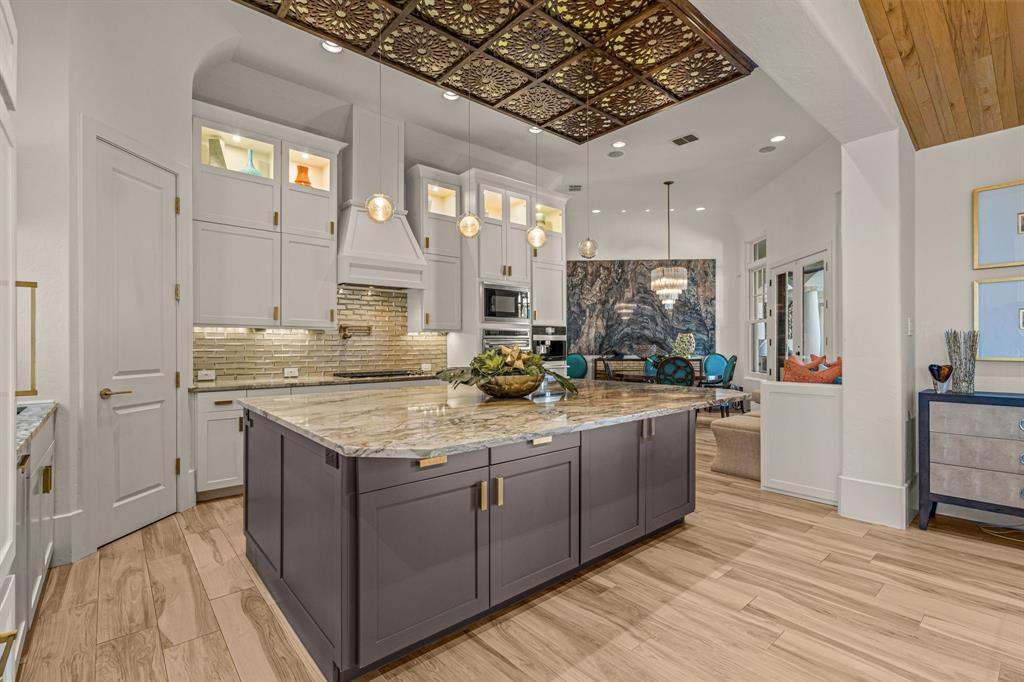 Kitchen looking toward the family room, island and gilded ceiling with a sightline to the agate wall
