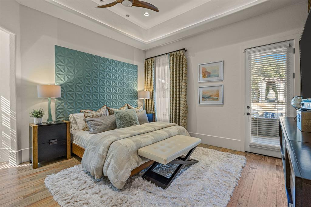 Secondary bedroom with a teal geometric accent wall and a door to the covered patio
