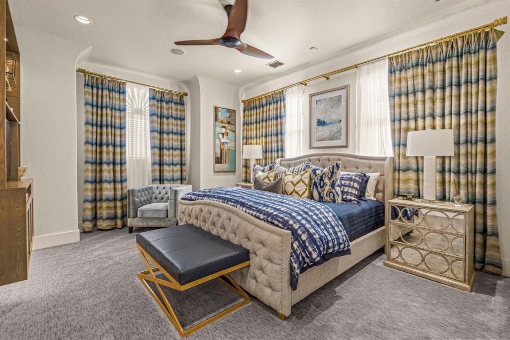Secondary bedroom with a cream tufted bed, striped drapery and mirrored nightstands