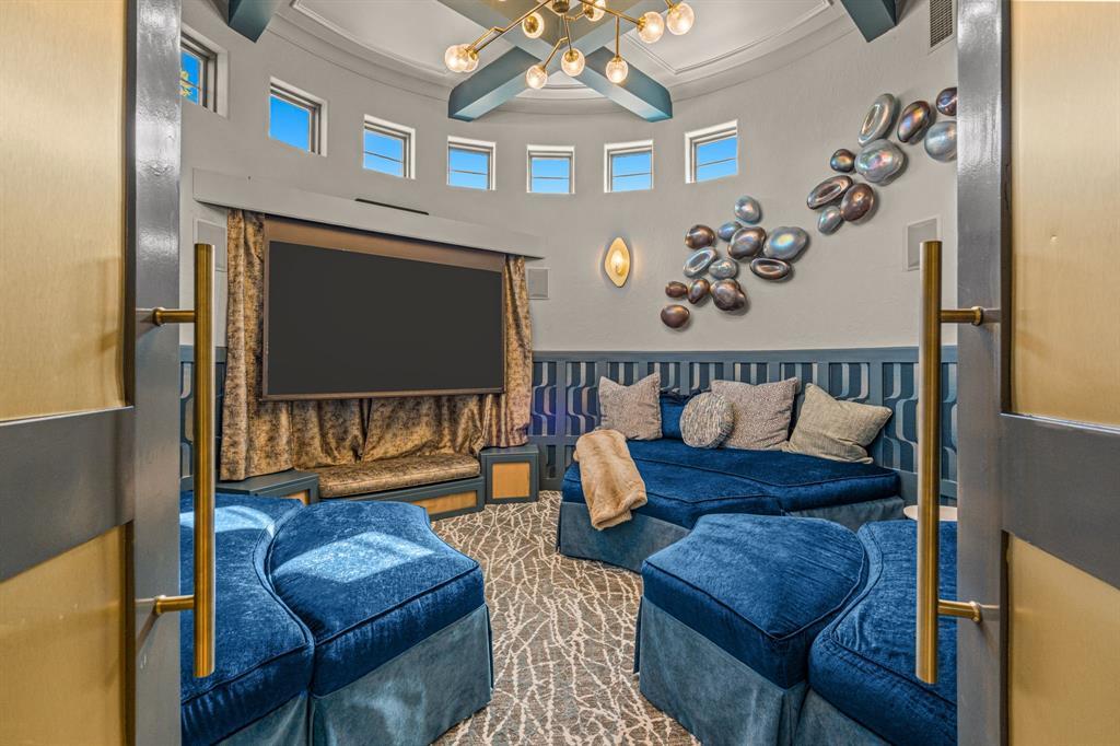 The circular media room: a genuinely round space with a domed ceiling, curved band of windows, and custom curved blue-velvet seating following the walls