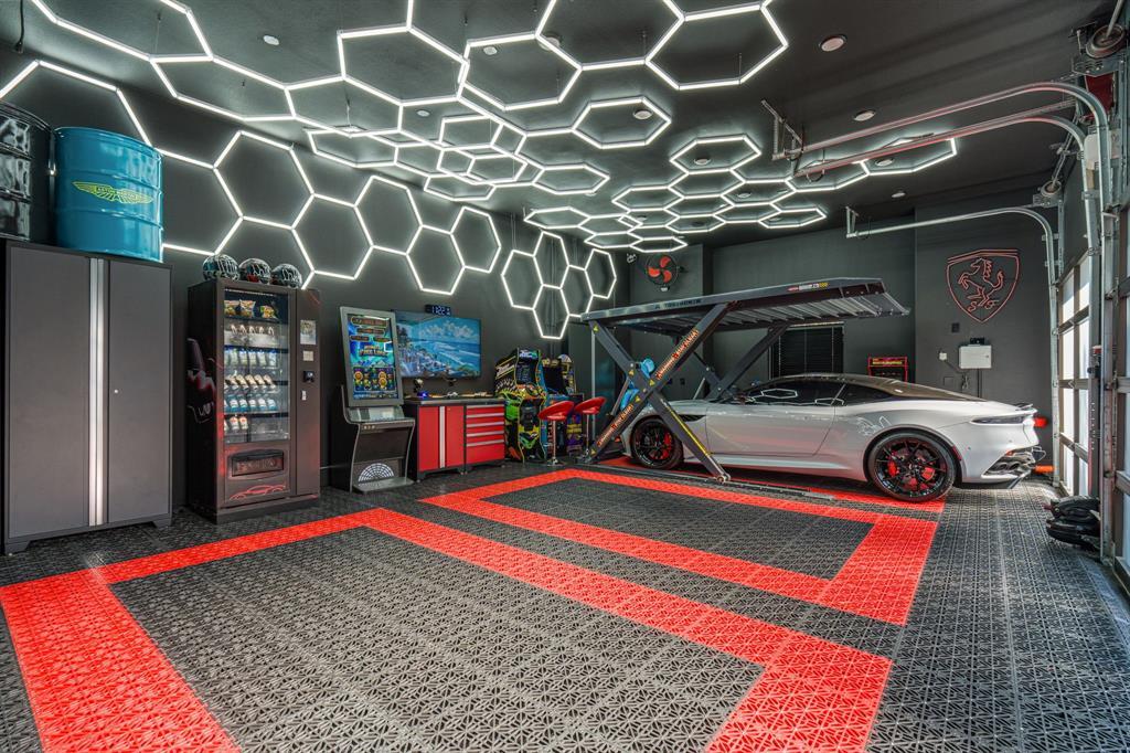 Car-enthusiast's garage with a hexagon LED ceiling grid, a car lift and racing-tile floor