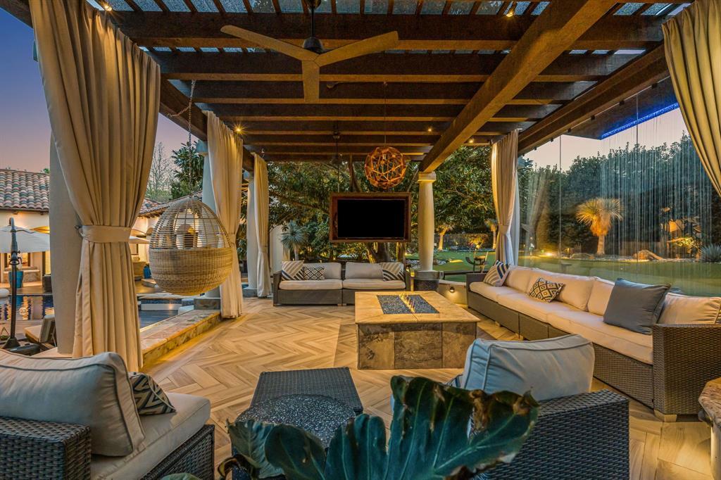 Covered outdoor living with a pergola, wicker sectionals and a herringbone floor beside the pool